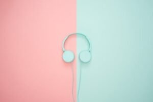 Minimalist headphones on a pink and mint background, artistic and modern.
